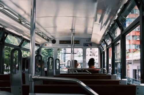Interior view of a city tram showing passengers and urban scenery outside, highlighting daily commuting.
