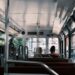 Interior view of a city tram showing passengers and urban scenery outside, highlighting daily commuting.